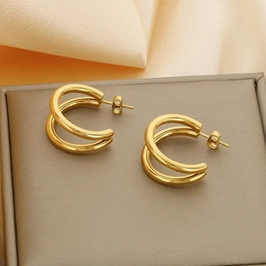 Detail shot of golden double hoop stainless steel earrings on a jewelry box display