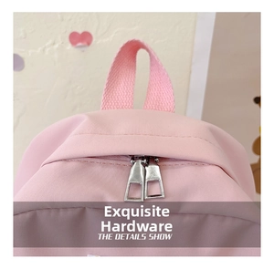 Detail shot of the pink backpack featuring dual metal zippers and a durable fabric handle