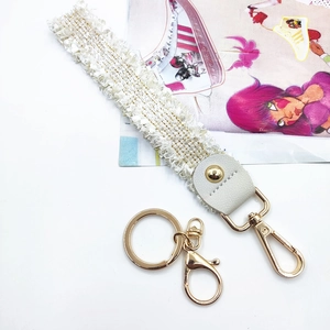 Elegant white lace wristlet keychain with leather trim and gold metal lobster clasp