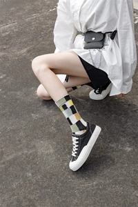 Close-up of stylish street-style socks with multi-color geometric pattern and canvas shoes