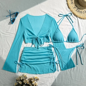 Set da spiaggia 4 pezzi blu brillante in maglia traforata su un fondo di lino naturale