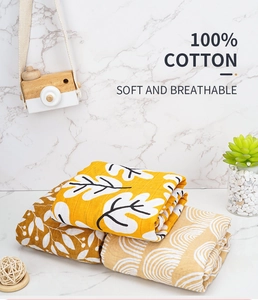 Three-pack soft muslin baby swaddle blankets in warm yellow and leaf patterns