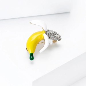 Macro shot of cute cartoon banana brooch with enamel finish and sparkling crystal rhinestones