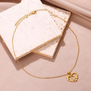 Collana a cuore dorata con ciondolo lettera D e dettagli floreali su base in pietra