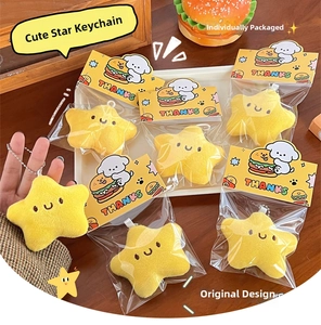 Primer plano del colgante de estrella de peluche amarillo con cara sonriente bordada