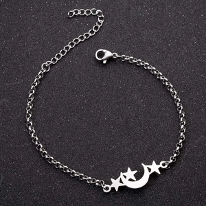 Detail of silver star and moon pendant bracelet with lobster clasp on dark background