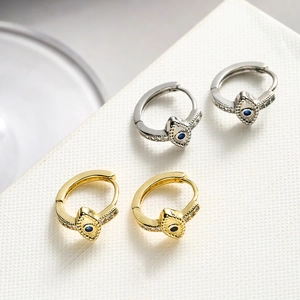 Gold and silver evil eye hoop earrings with sparkling cubic zirconia on white board