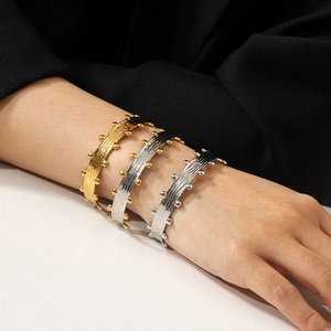 Three-color brushed texture cuff bracelets with bead details on a model wrist