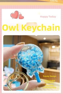 Close-up of a blue floral lollipop keychain with a transparent bow and golden clasp
