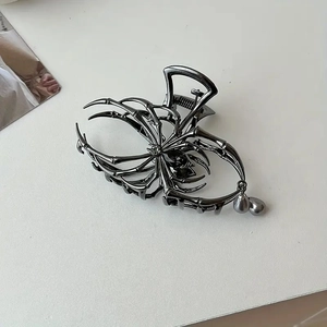 Close-up of gothic spider hair claw in gunmetal alloy with grey pearl tassel detail