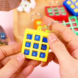 Gros plan du jeu de morpion porte-clés jaune avec boutons bleus X et O en utilisation