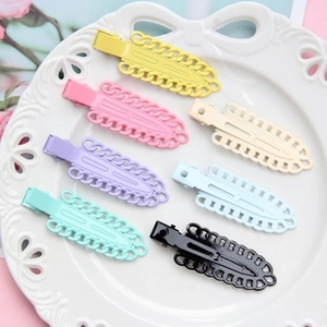 Detailed set of seven colorful gradient metal BB hair clips arranged on a white ceramic plate