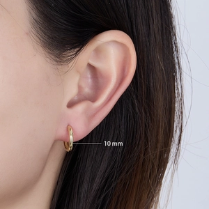 Detail view of 10mm gold polished sterling silver hoop earring worn on model ear