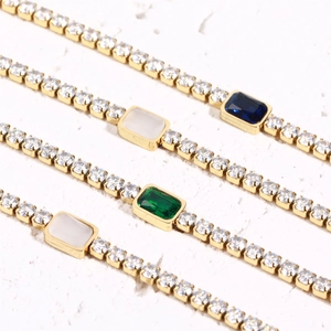 Detail of four 18K gold plated tennis bracelets with emerald-cut colored stones