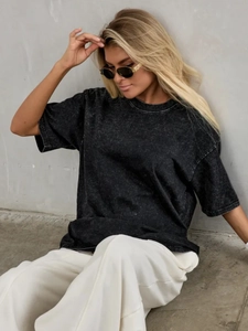Detail of washed black vintage cotton T-shirt showing distressed texture and crew neck