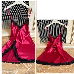 Red satin nightgown with black lace trim and crossover back straps in domestic setting