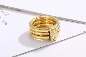 Detail of 18k gold plated triple-layer ring featuring a sparkling CNC diamond buckle
