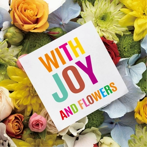 Detail view of square white gift card with multi-color lettering nestled in vibrant flowers