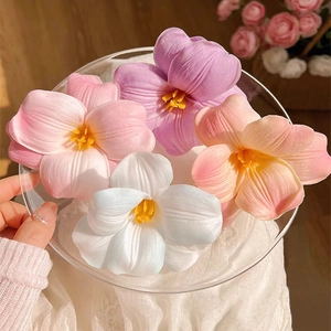 Realistic artificial tulip hair clips in various colors displayed on a clear plate