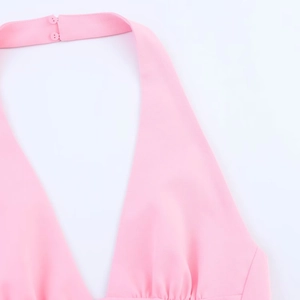 Detail eines rosa Neckholder-Midikleides mit Doppelknopfverschluss und V-Ausschnitt