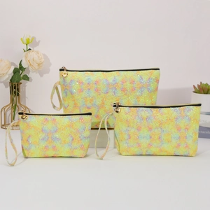 Three-piece set of shimmering yellow iridescent lace toiletry bags with black zippers