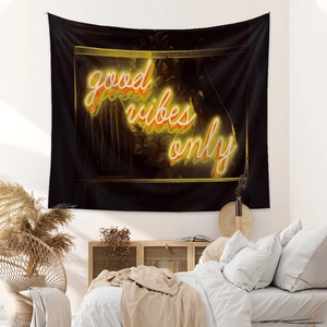 Detail of bohemian black tapestry with glowing neon style good vibes only quote on a wall