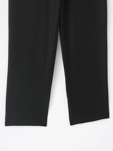 Détail de la texture du tissu en sergé et de l'ourlet du pantalon décontracté noir
