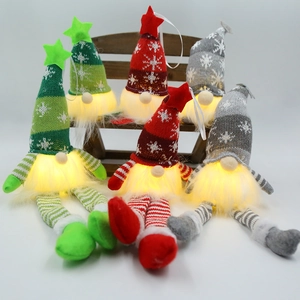 Gnomes de Noël avec chapeaux en tricot flocon et lumières LED sur banc en bois