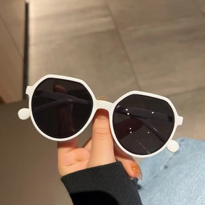 Fashionable oversized white geometric sunglasses with dark grey lenses in hand