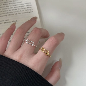 Close-up of minimalist geometric 925 silver rings in gold and silver on a finger