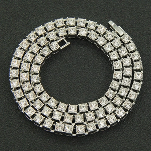 Macro shot of a silver hip-hop tennis necklace with round clear stones on a black background