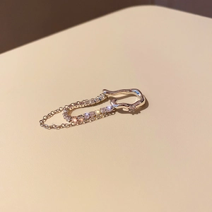 Close-up of gold layered butterfly ear cuff with dangling chains and sparkling zircons