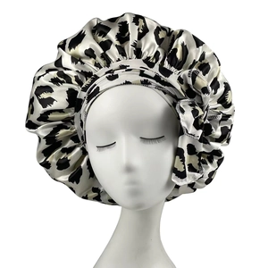 Detail of leopard print satin sleep cap showing the elastic wide band and silky texture