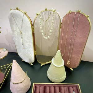 Golden folding jewelry display stand with velvet panels and conical ring holder