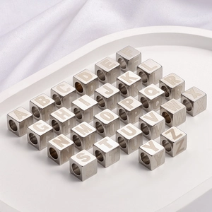 Stainless steel square alphabet beads set for DIY jewelry making in a white tray