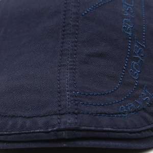 Detail of dark blue cotton beret featuring embroidered GOYST text and durable stitching