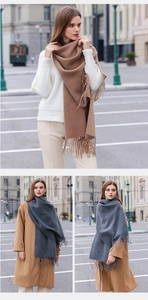 Detail of soft solid color scarves in camel and dark grey with fringe tassels for winter