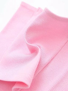 Close-up of pink ribbed knit fabric texture showing high elasticity and soft material