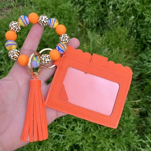 Detail of orange silicone bead wristlet with leopard print beads and tassel card holder