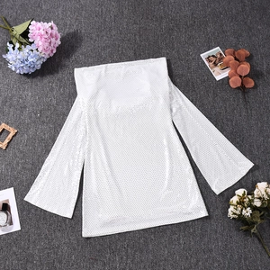 Vue à plat d'une robe en maille blanche à pois noirs avec manches longues évasées sur fond gris