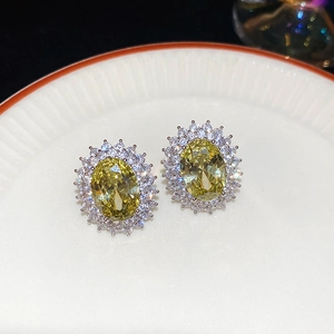 Close-up of vintage oval yellow zircon stud earrings with double halo sparkle stones