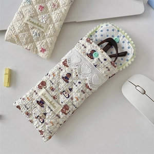 Close-up of quilted cotton eyewear pouch with cute bear pattern and lace trim detail