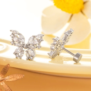 Elegant silver butterfly stud earrings with sparkling cubic zirconia on a ceramic tray