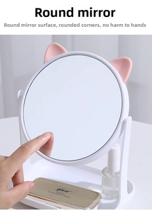 Detail of white vanity mirror with pink cat ears showing a rotating stand and storage tray