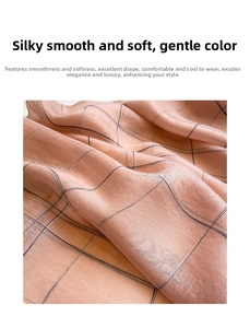 Close-up of peach silk wool scarf fabric showing thin windowpane plaid pattern and soft texture