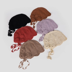 Detail showing six colorful handmade crochet berets with fringe and floral accents