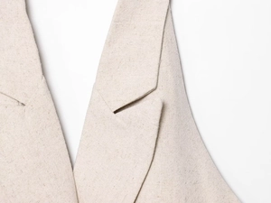 Vista macro dettagliata del gilet minimalista in lino con un classico colletto a revers