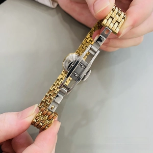 Detail of the high-polished gold and silver stainless steel watch band with butterfly clasp