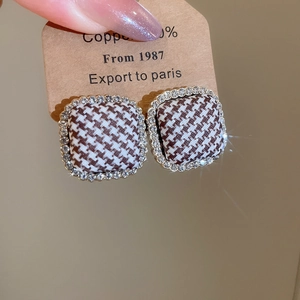 Close-up of square houndstooth stud earrings with sparkling crystal accents
