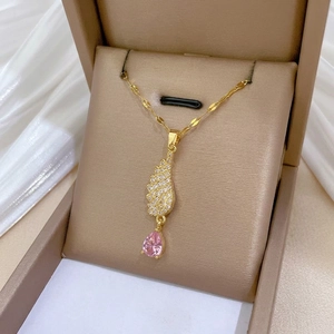 Golden necklace with angel wing pendant and pink teardrop zircon in a luxury jewelry box